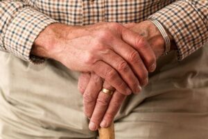 Old man's hands on cane elder abuse